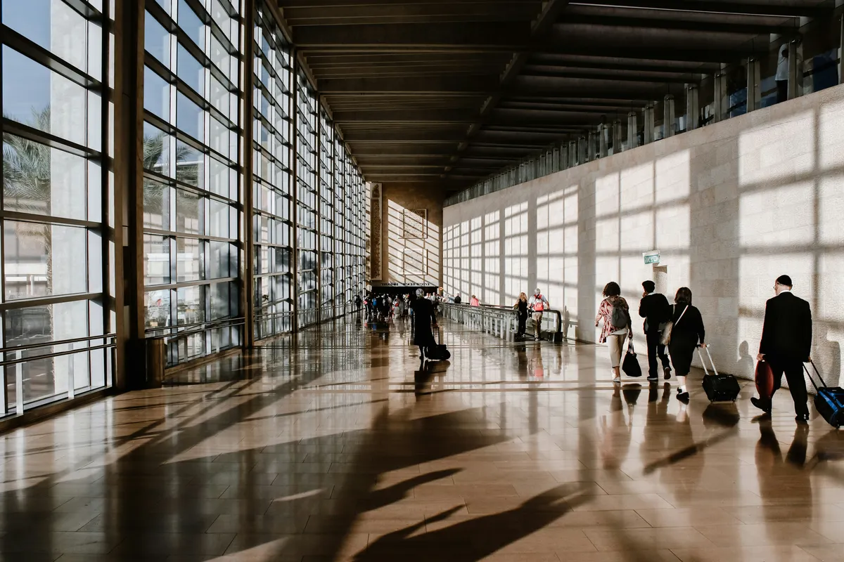 Travelers walking through airport terminal with luggage