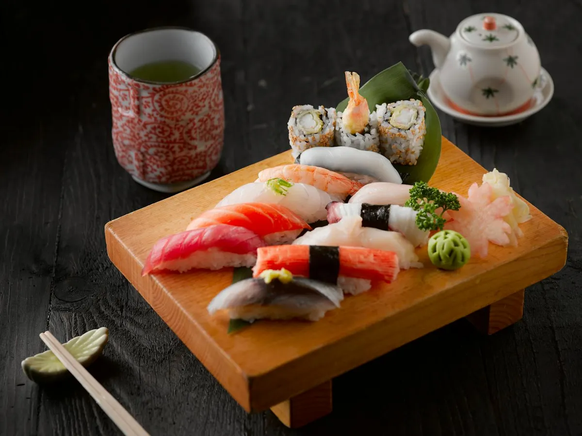 Japanese sushi platter with green tea on wooden board